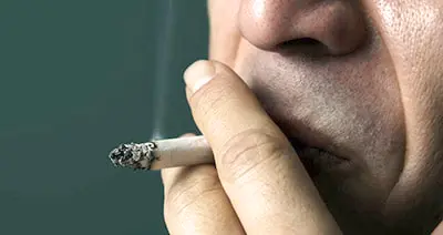 Une image montrant un espace public sans fumée, avec des symboles d'interdiction de fumer, illustrant l'importance de créer des environnements sans fumée pour protéger la santé des non-fumeurs.