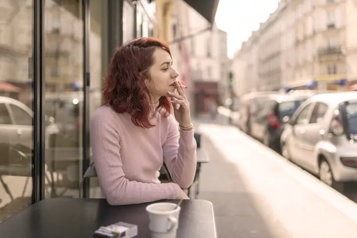 Une image illustrant une personne souffrant d'anxiété, tenant une cigarette tout en se sentant nerveuse et stressée, mettant en évidence les effets du tabagisme sur l'anxiété et le bien-être émotionnel.